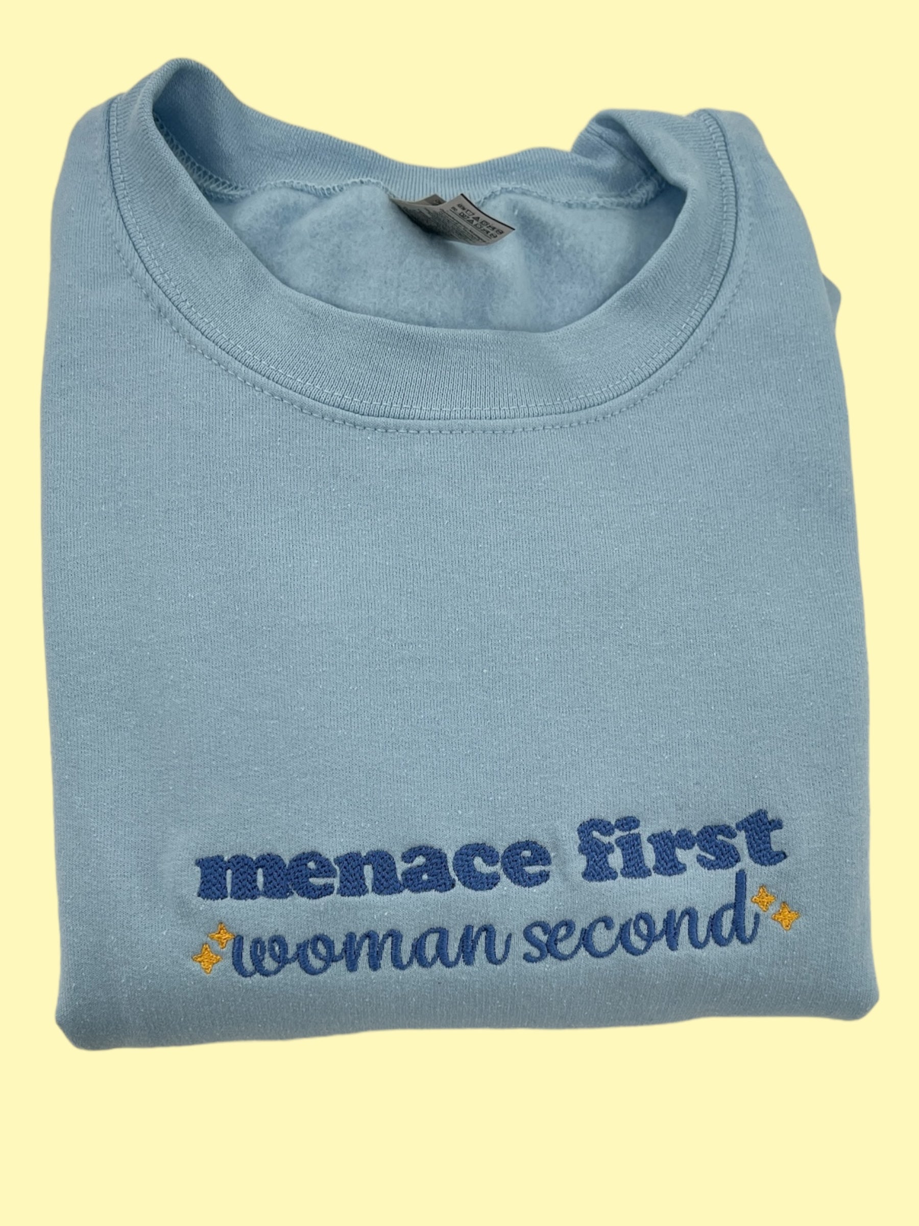 a blue t - shirt that says menace first woman second