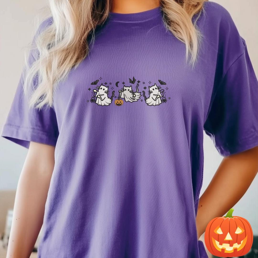 a woman wearing a purple t - shirt with a ghost on it