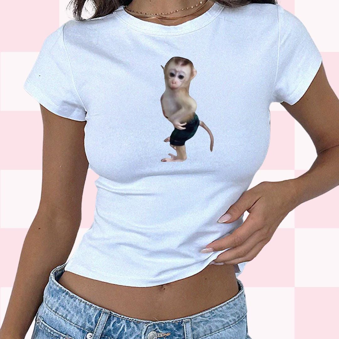 a woman wearing a white shirt with a monkey on it