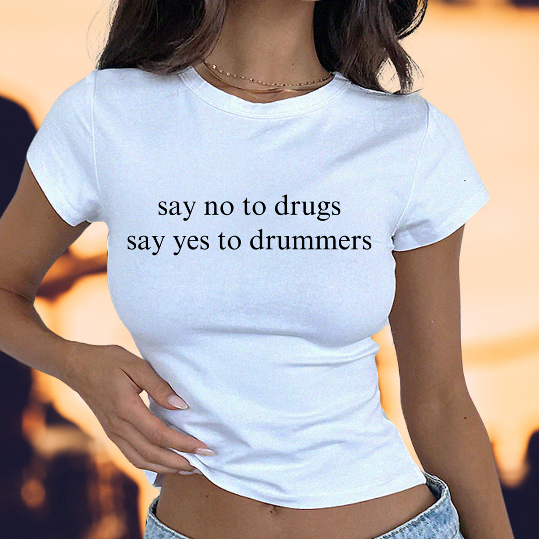 a woman wearing a white shirt that says say no to drugs say yes to drummer