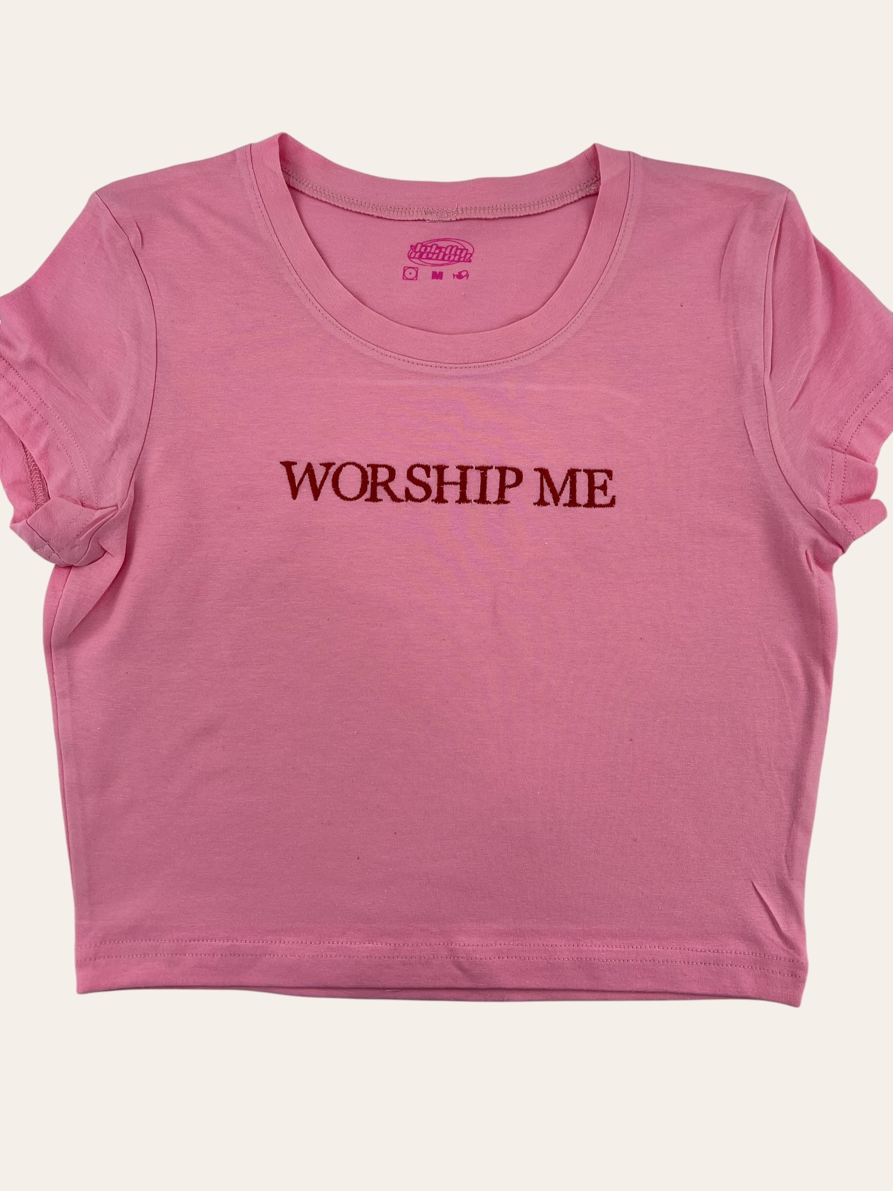 a pink shirt that says worship me