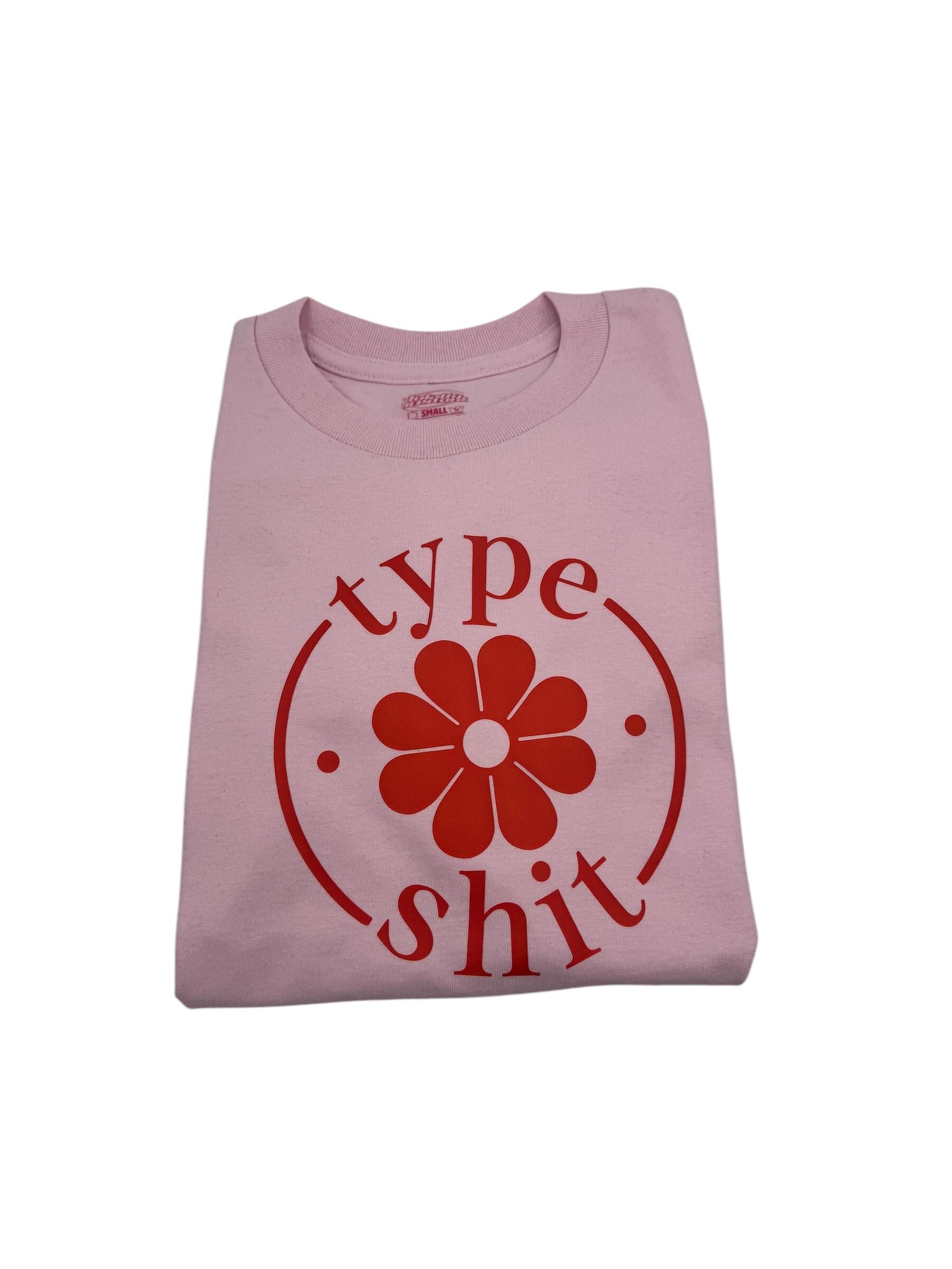 a pink shirt with a flower on it