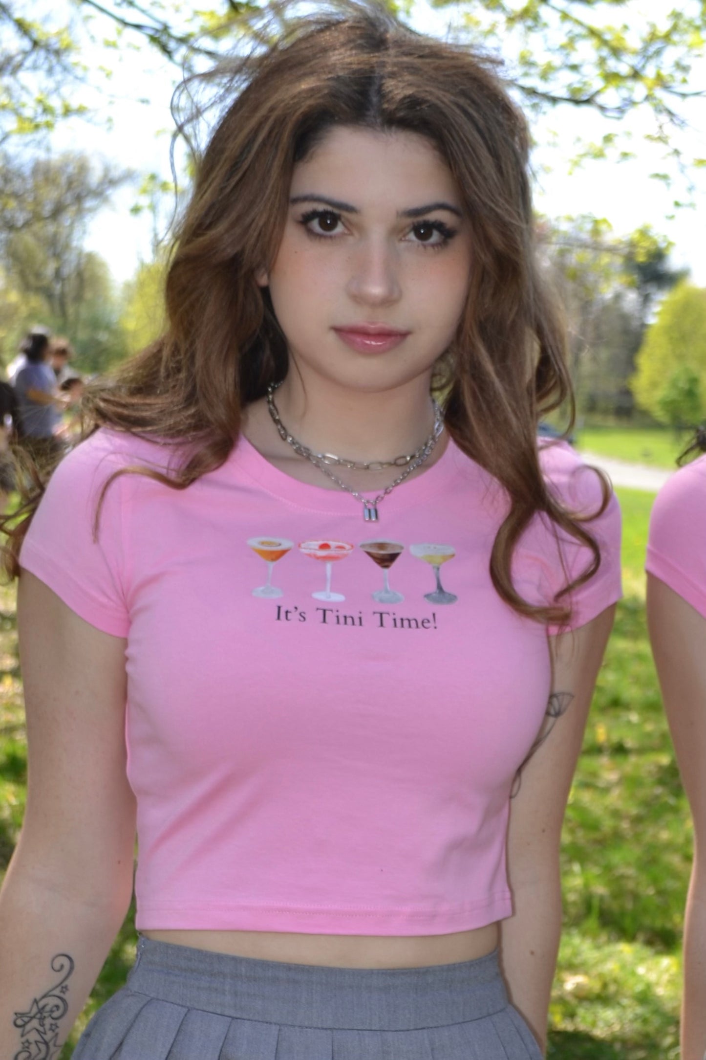 a woman in a pink shirt and a gray skirt