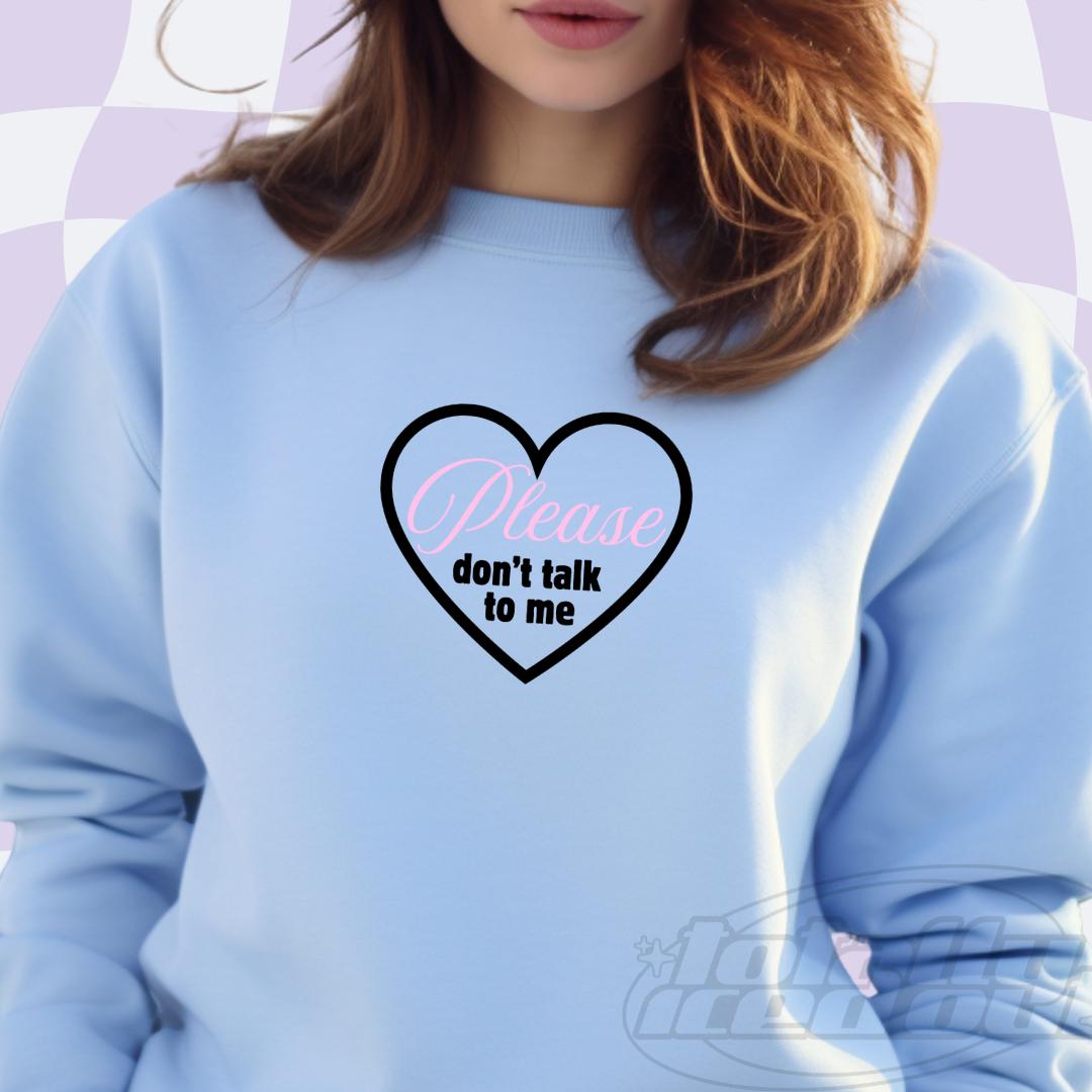 a woman wearing a blue sweatshirt with a heart on it