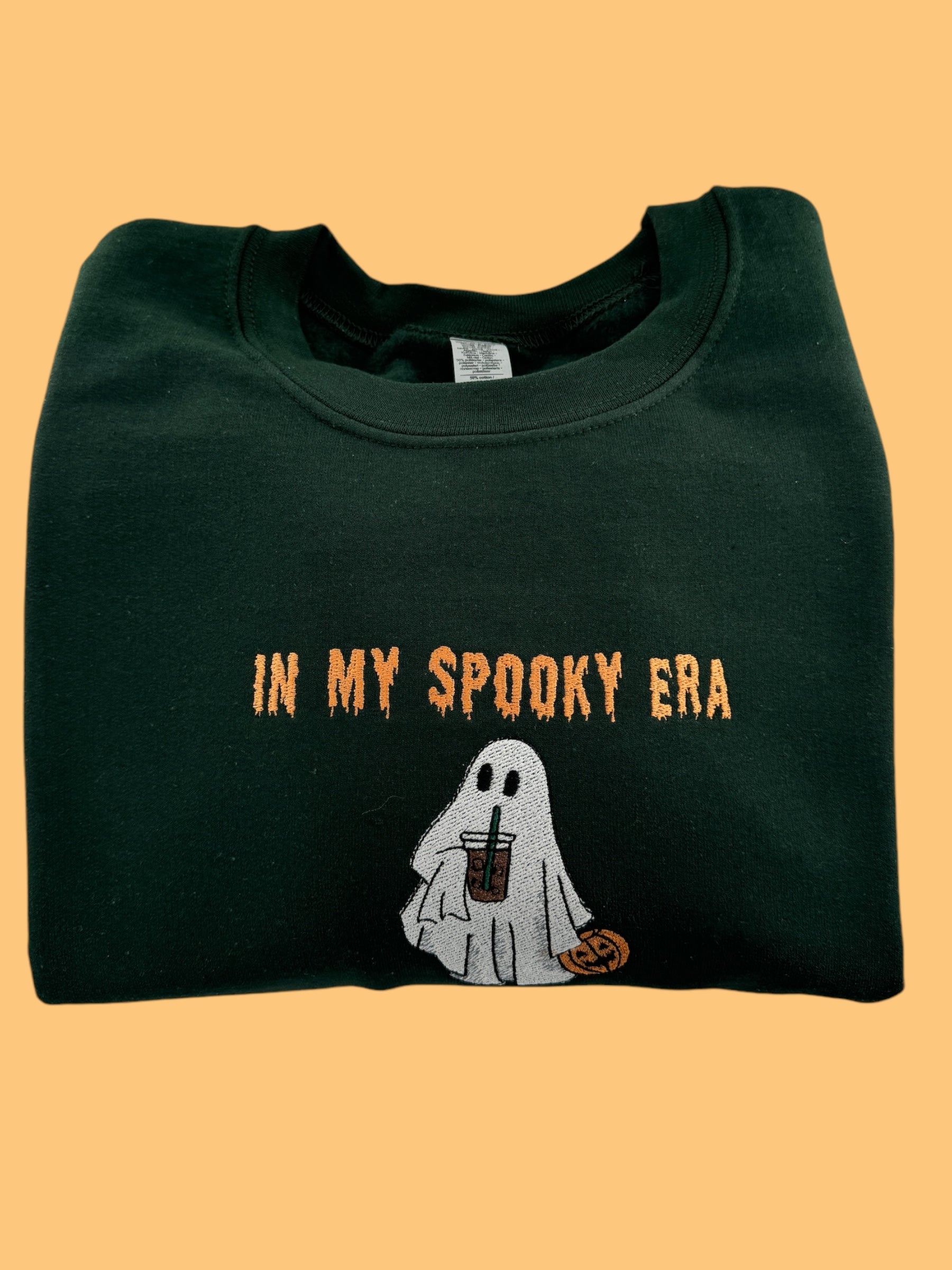 a green shirt with a ghost holding a drink