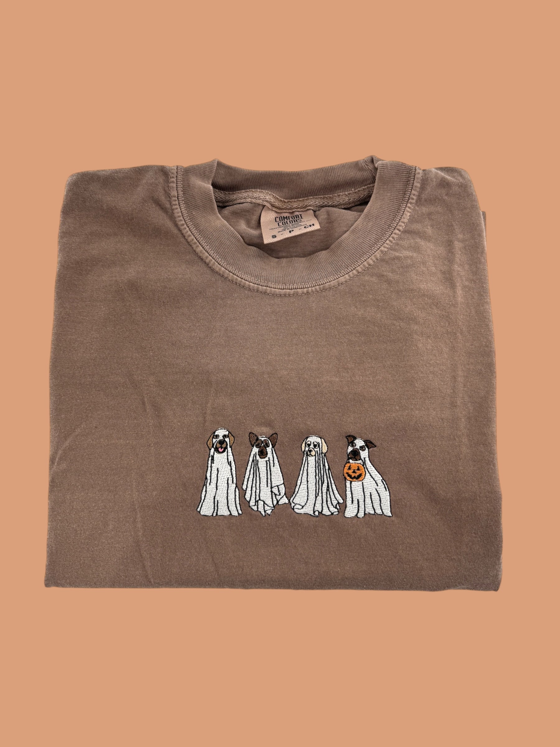 a brown t - shirt with three dogs on it