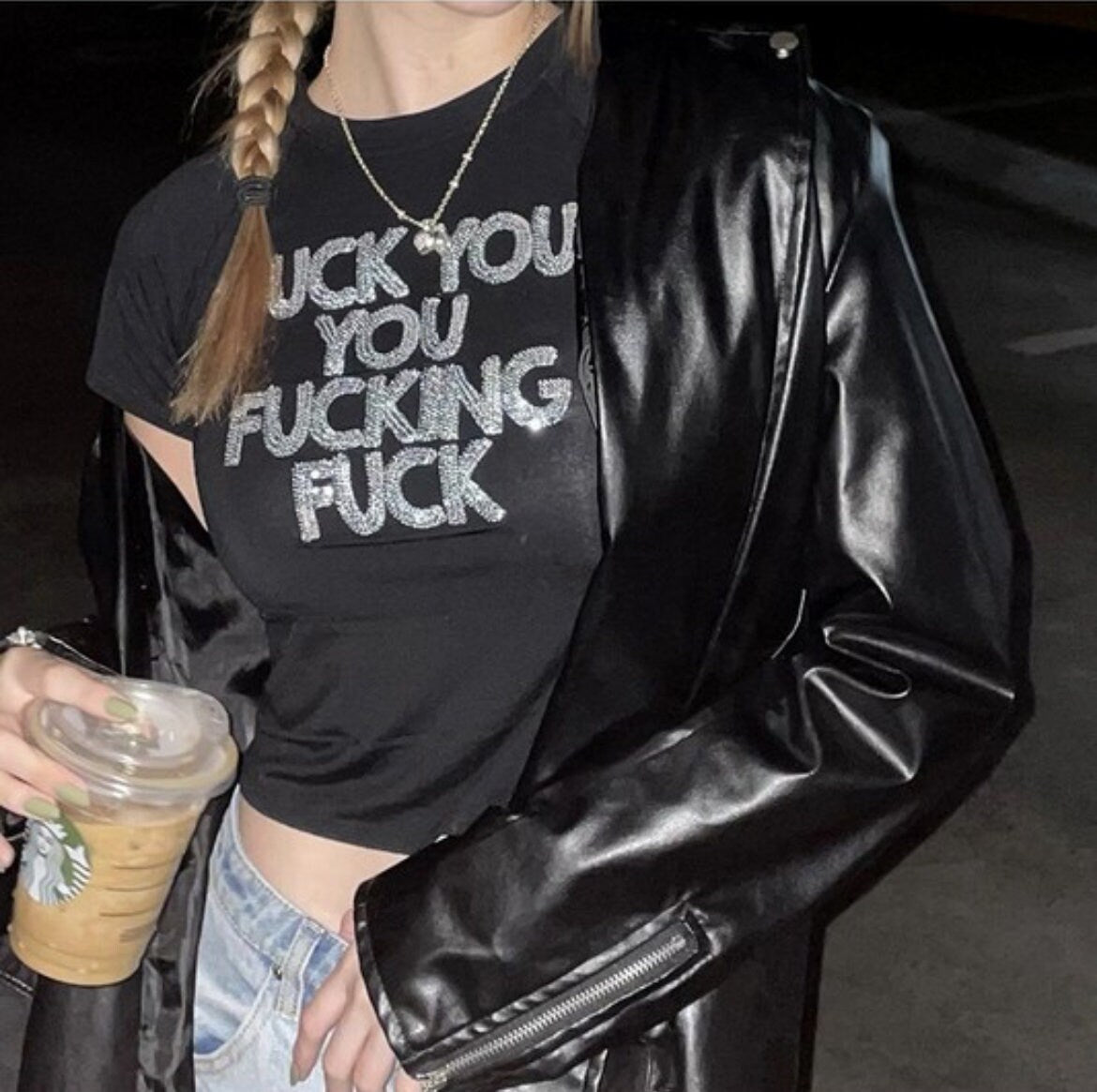 a woman in a black shirt and jacket holding a drink