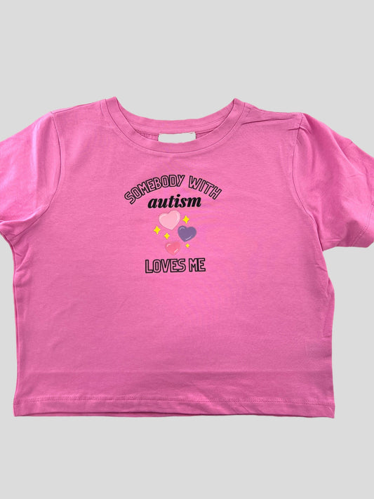 a pink t - shirt with the words autism loves me on it