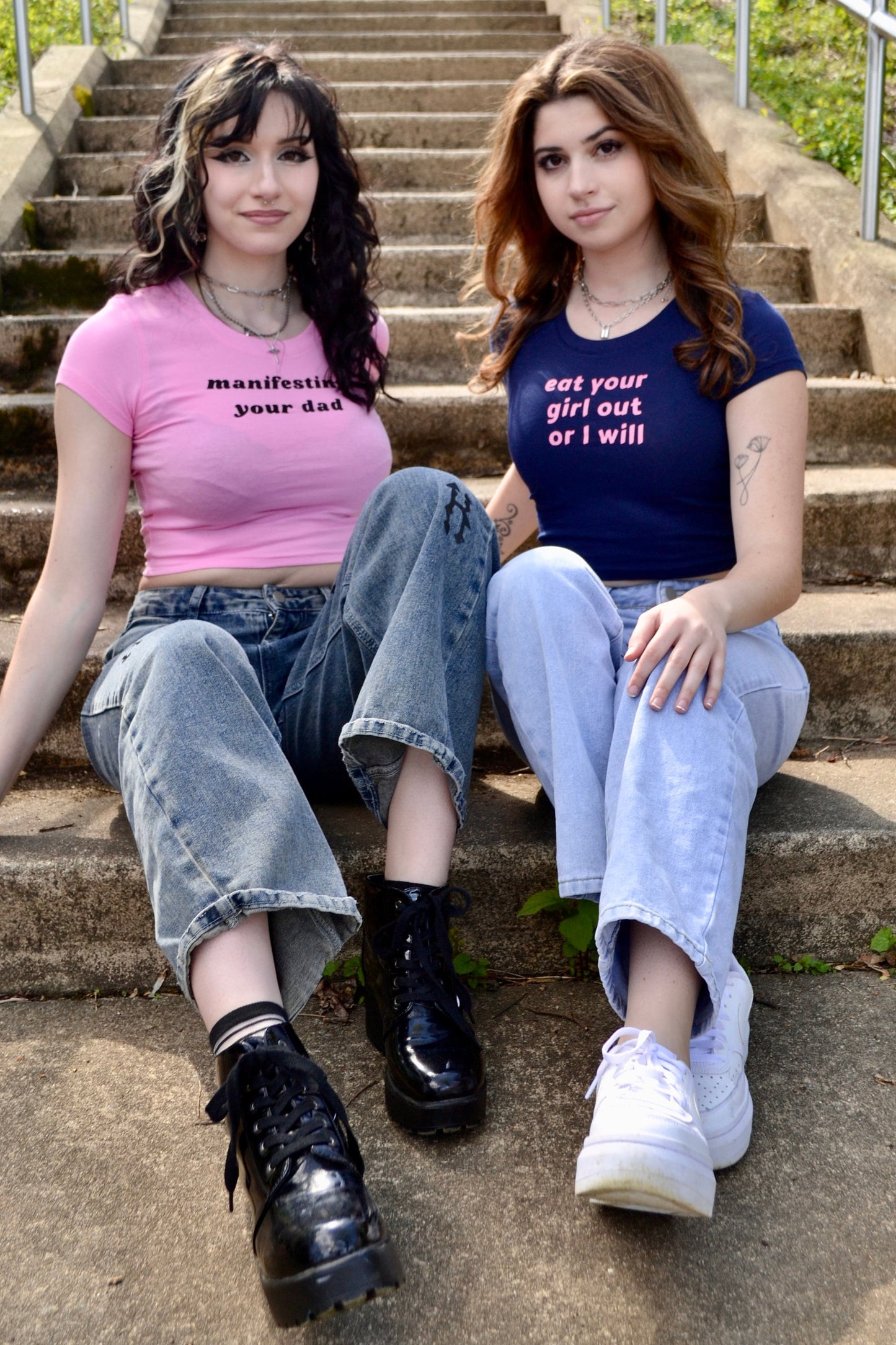 two young women sitting on the steps of a set of stairs