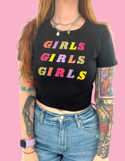 a woman wearing a black shirt with the words girls girls on it