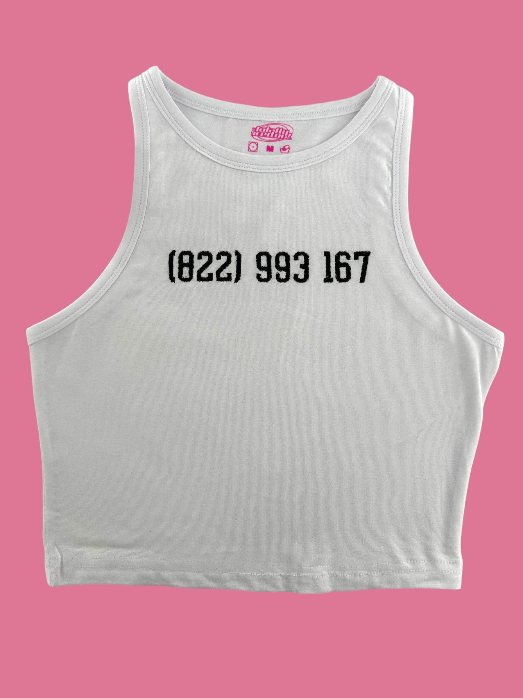 a white crop top with a pink background