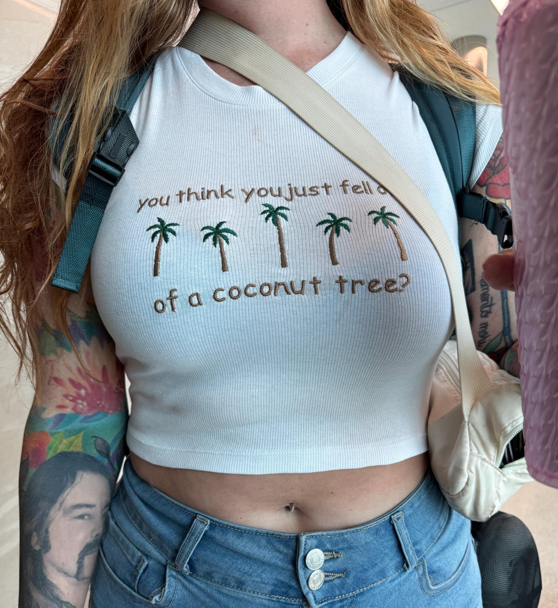 a woman wearing a white shirt with palm trees on it