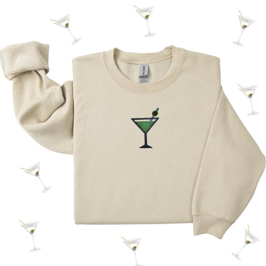 a white sweater with a green martini on it