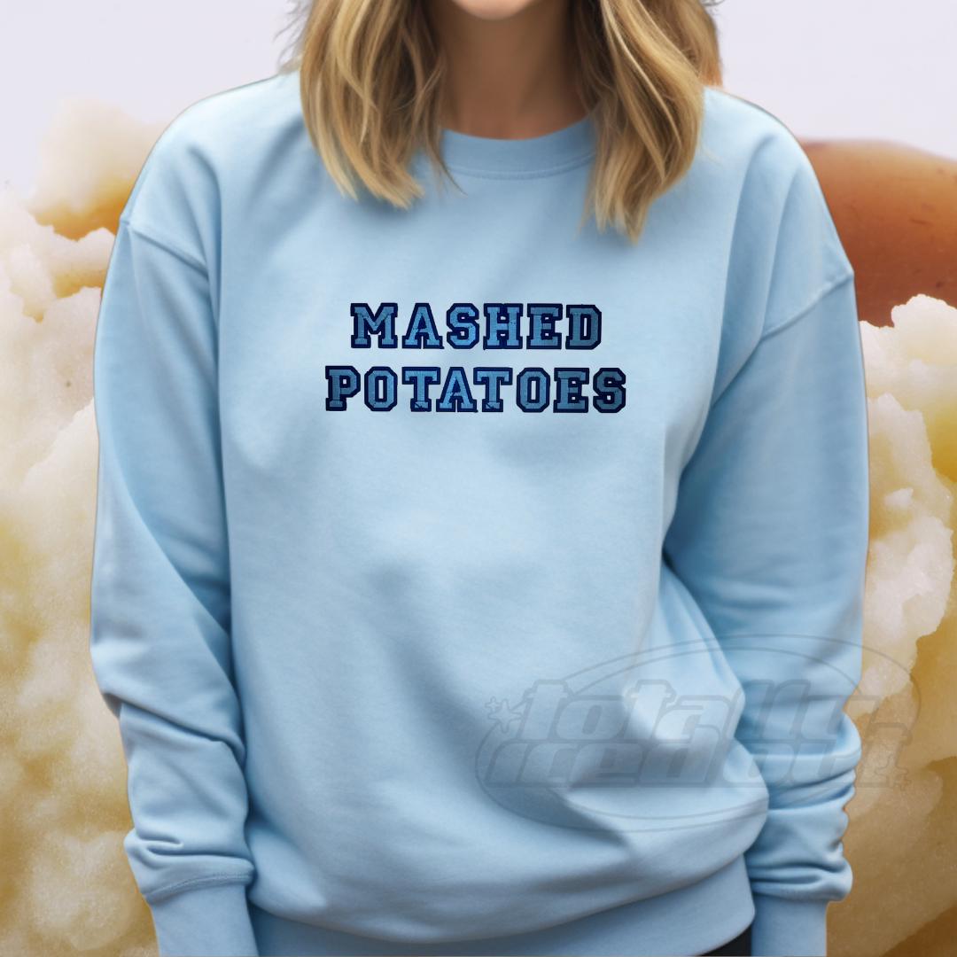 a woman wearing a blue sweatshirt that says mashed potatoes