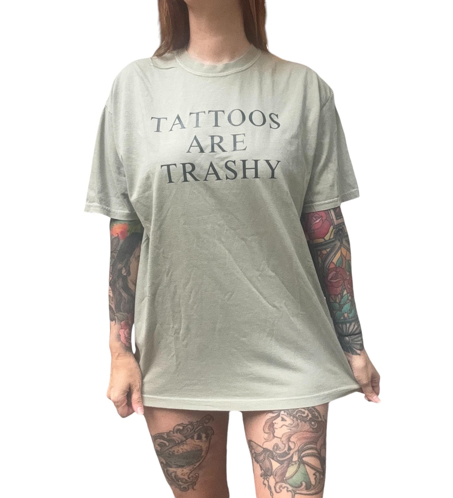 a woman with tattoos on her legs wearing a shirt that says tattoos are trashy