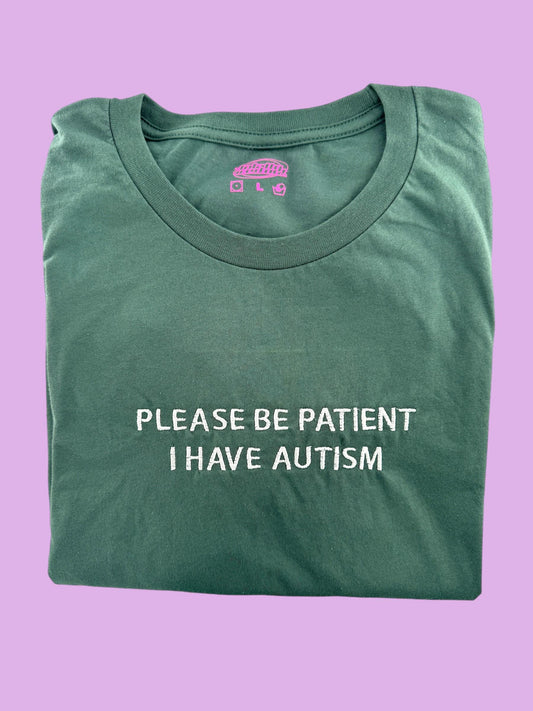 a green t - shirt that says please be patient i have autism