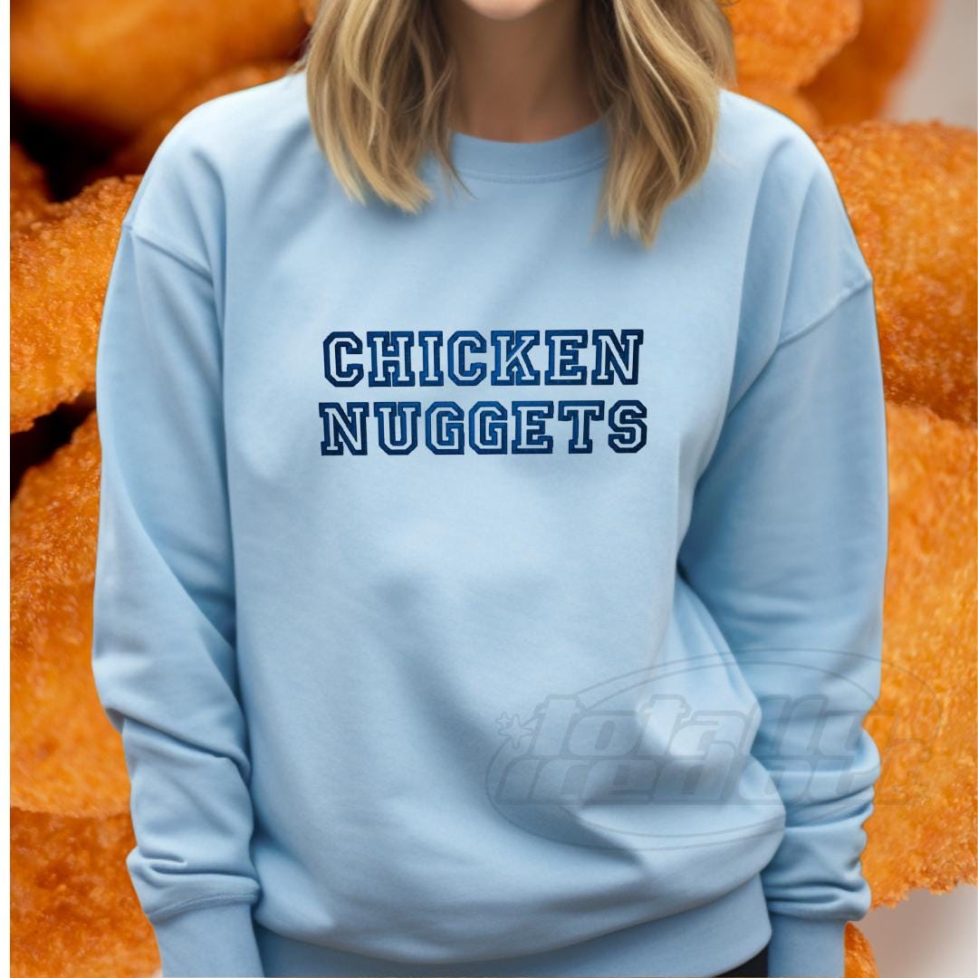 a woman wearing a blue sweatshirt with the words chicken nuggets on it