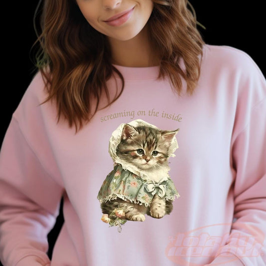 a woman wearing a pink sweatshirt with a cat on it