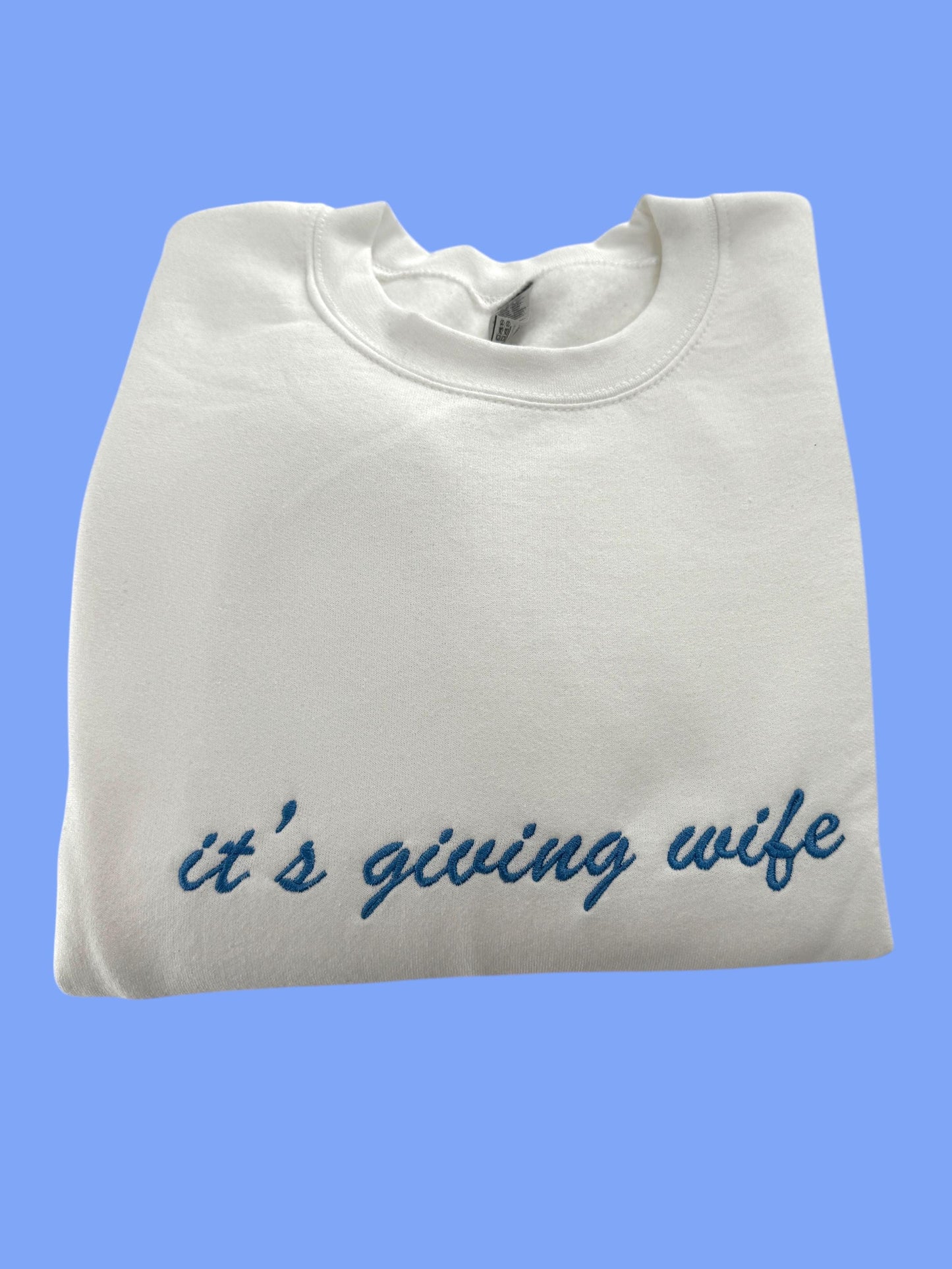 a white t - shirt that says it's giving wife