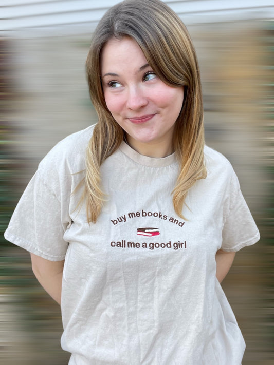 a woman with a white shirt that says buy me books and call me a good