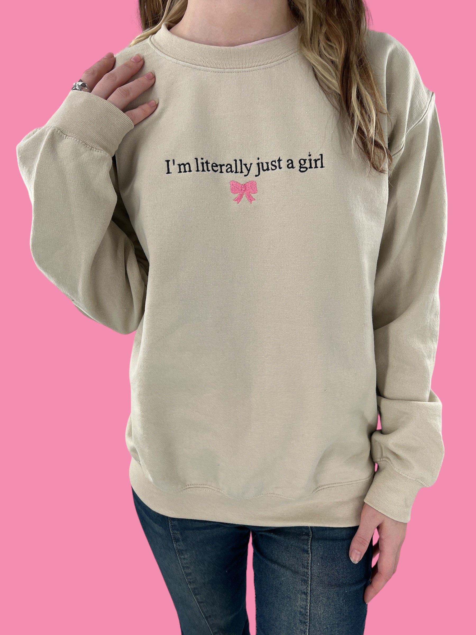 a woman wearing a sweatshirt that says i&#39;m literally just a girl