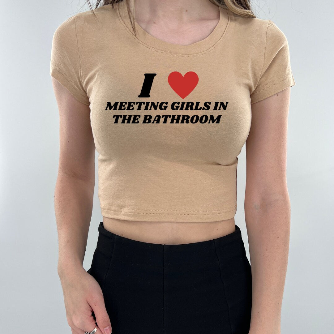 a woman wearing a t - shirt that says i love meeting girls in the bathroom